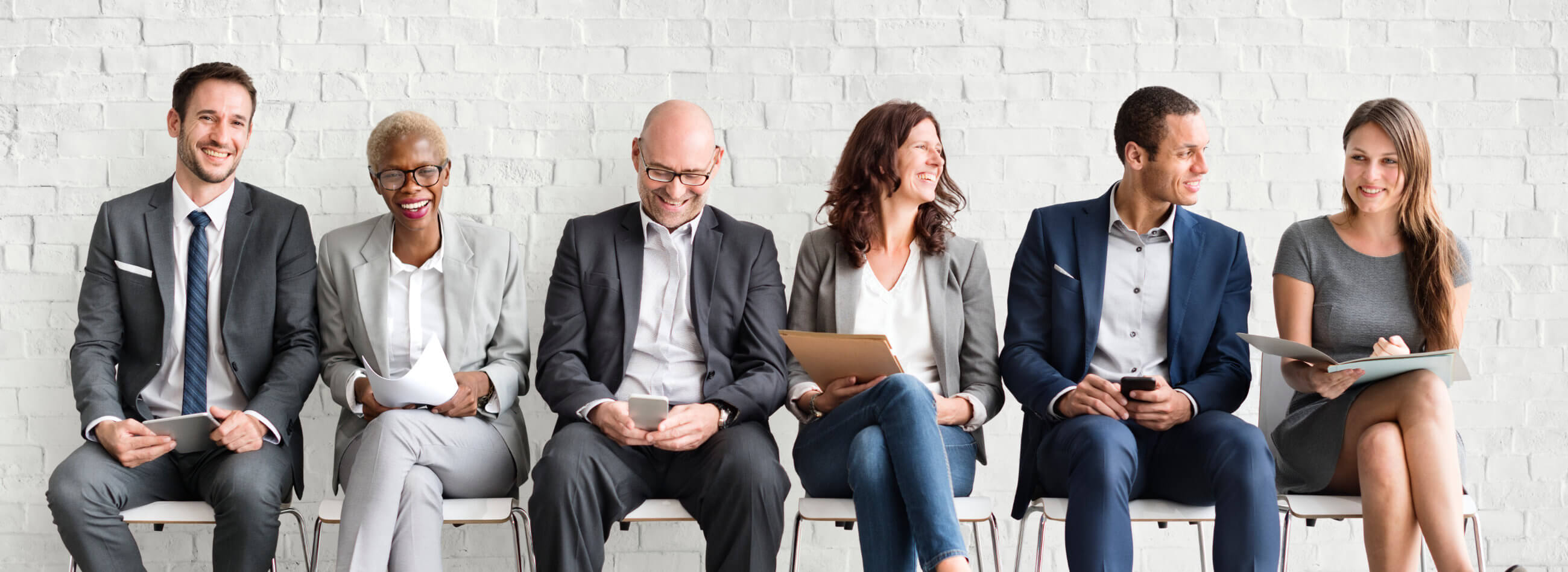 four collegues talking while holding coffee cups